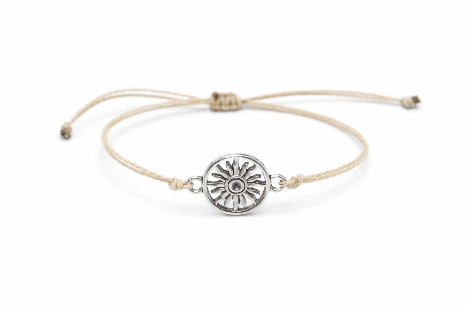 Beige bracelet with a silver sun charm on a white background
