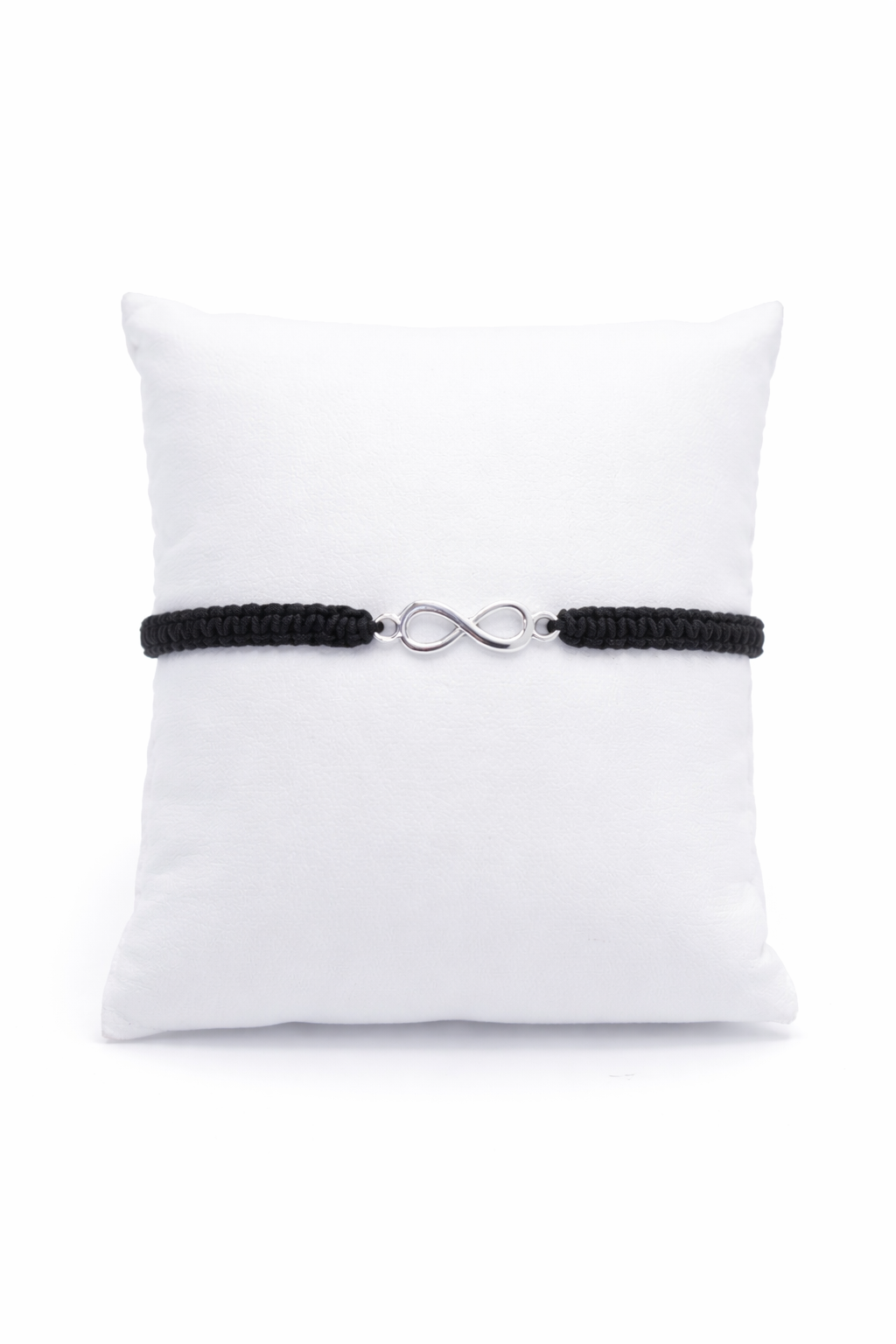 Black bracelet with a silver infinity charm on a white pillow