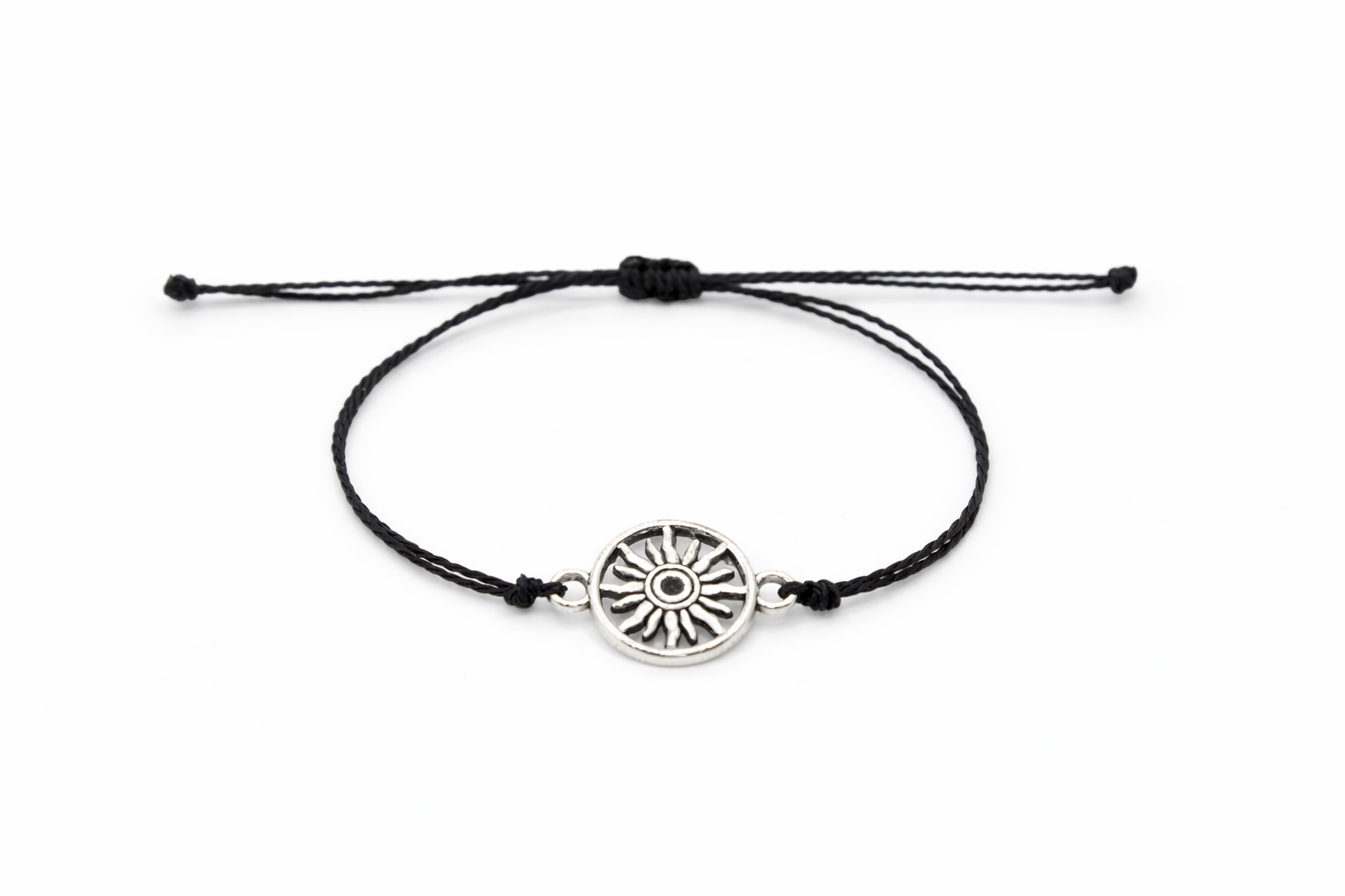 Black cord bracelet with a silver sun charm on a white background