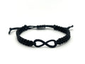 Black macrame bracelet with an infinity symbol on a white background