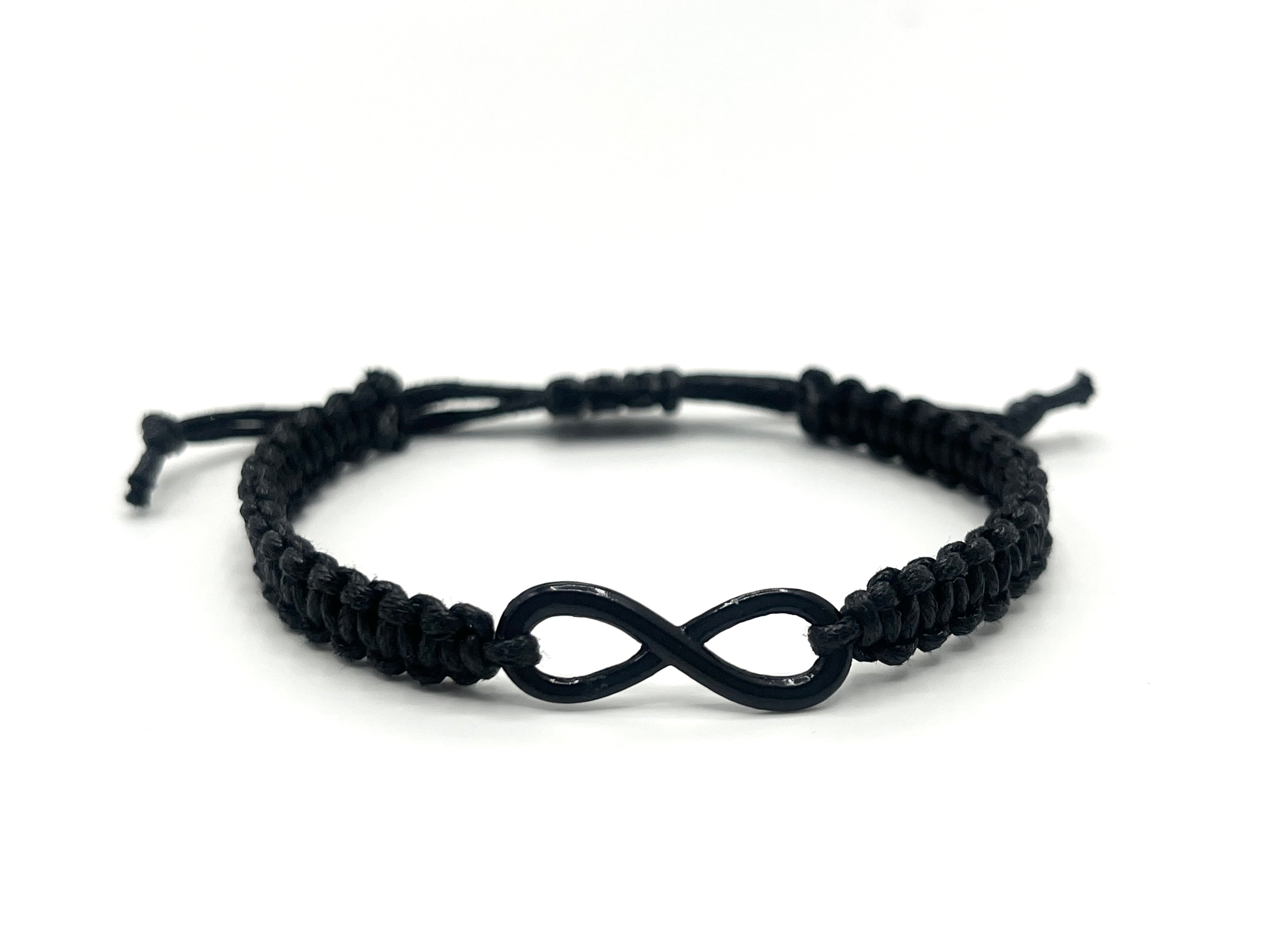 Black macrame bracelet with an infinity symbol on a white background