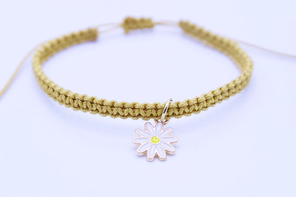 Bracelet with a daisy charm on a light background