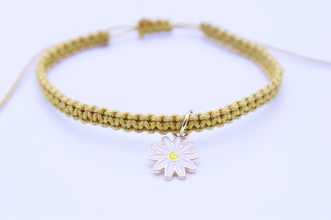 Bracelet with a daisy charm on a light background