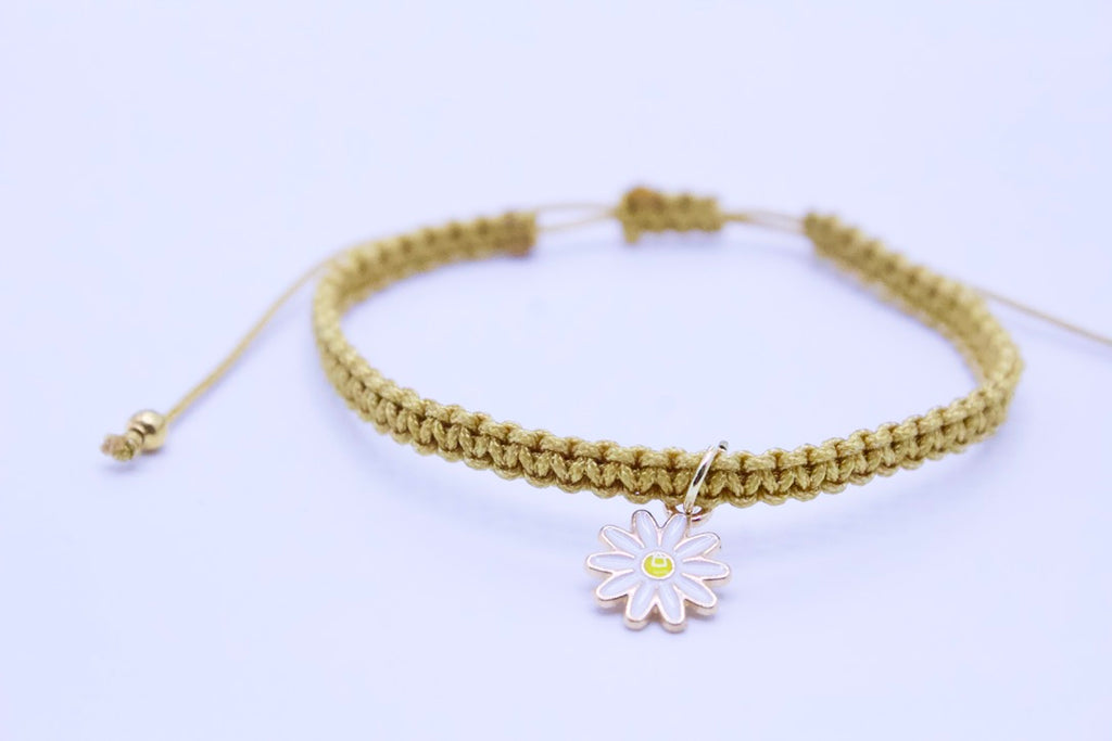 Bracelet with a daisy charm on a light background
