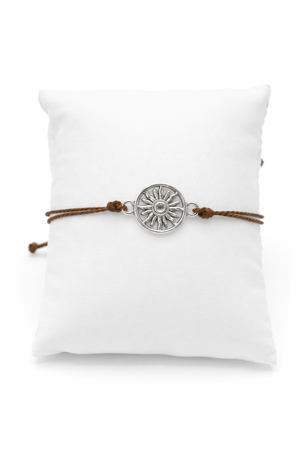 Bracelet with a sun charm on a white cushion