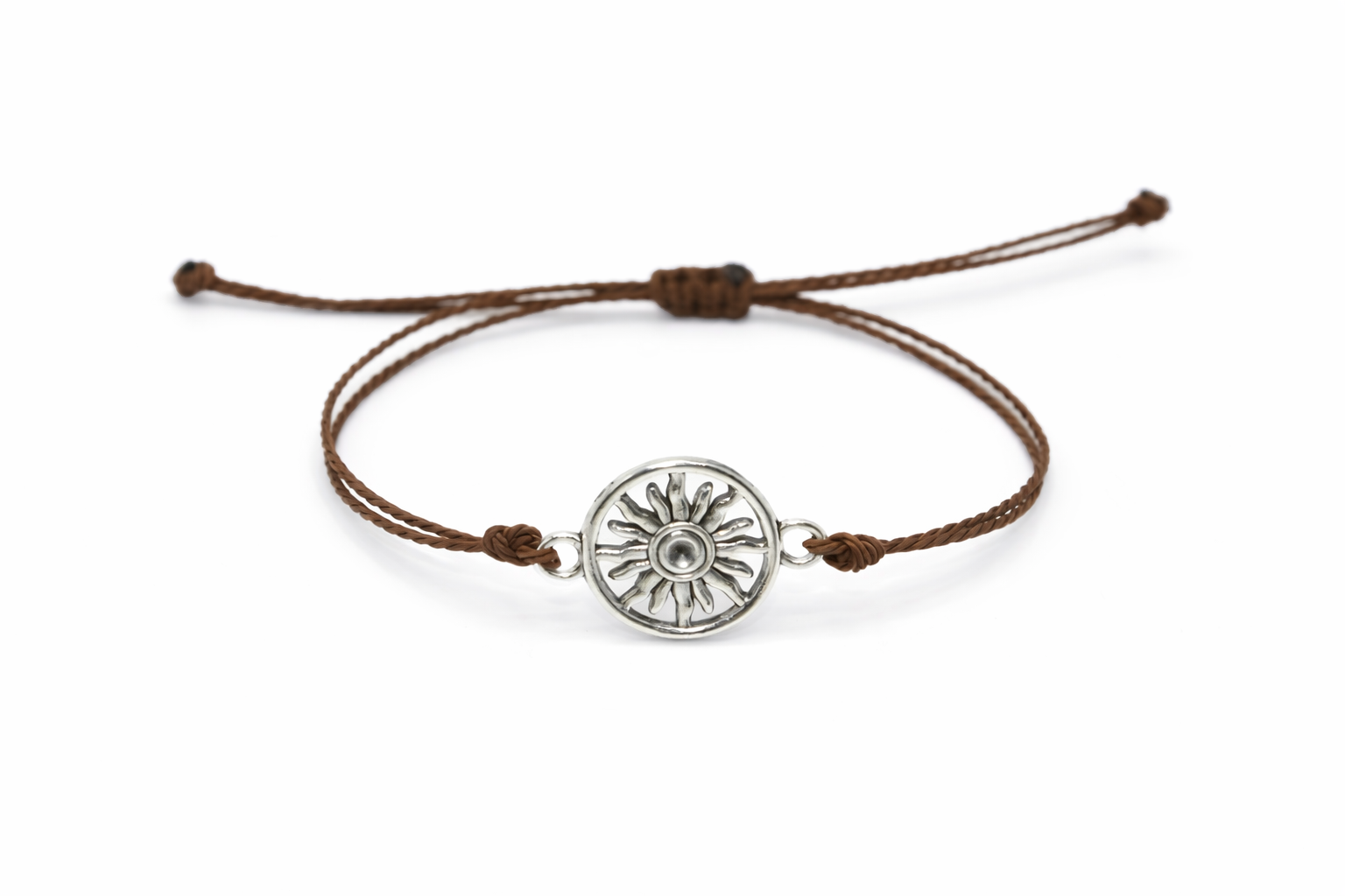 Brown cord bracelet with a silver sun charm on a white background