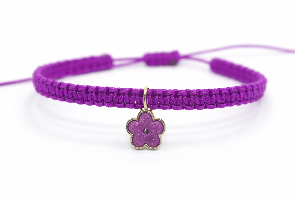 Close-up of handmade flower charm on macramé bracelet
