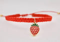Close-up of strawberry charm on handmade macrame bracelet