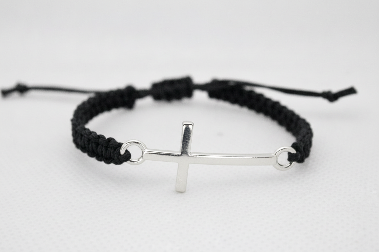 Close up of cross charm on adjustable macrame bracelet