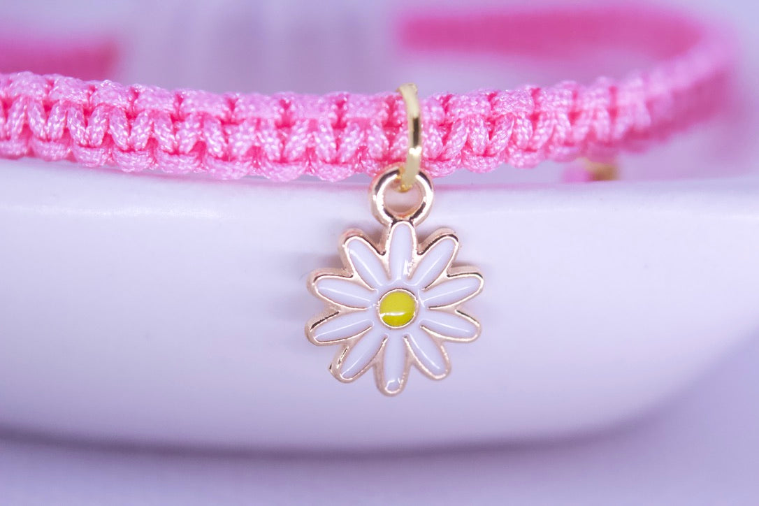 Close up of daisy flower charm on delicate adjustable bracelet