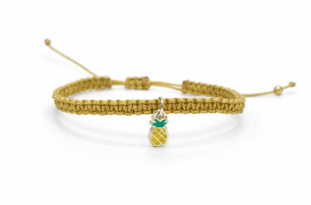 Close up of gold pineapple charm bracelet detail