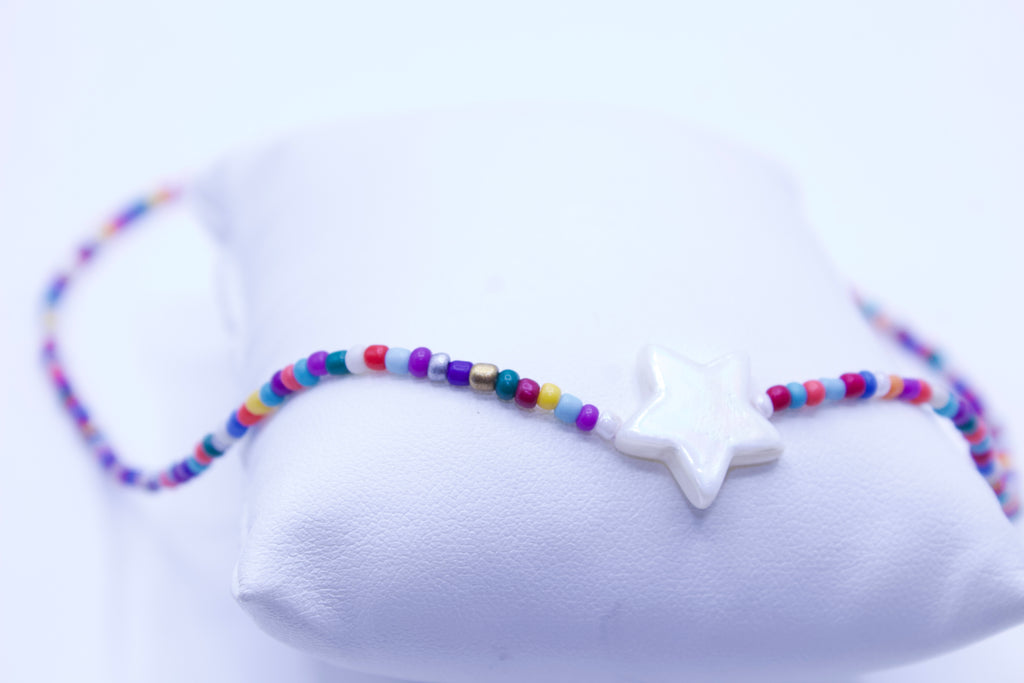 Colorful beaded bracelet with a star-shaped charm on a white background