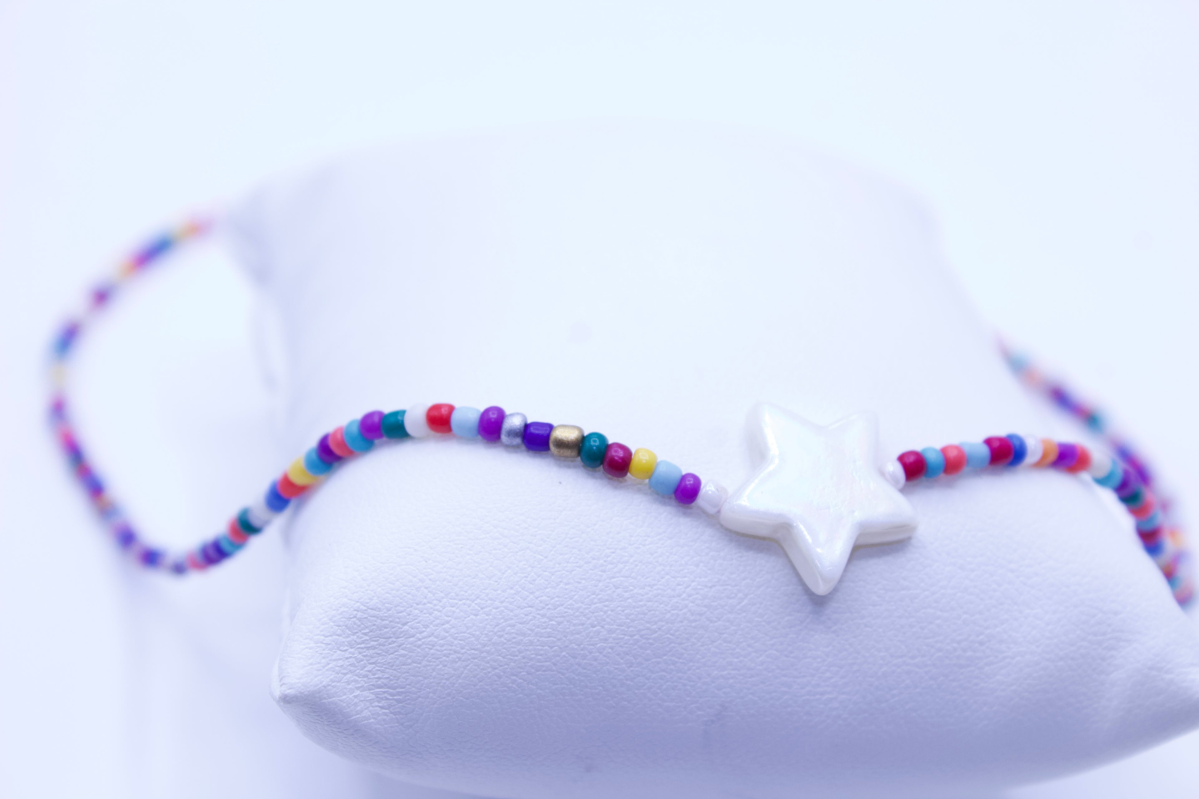 Colorful beaded bracelet with a star-shaped charm on a white background