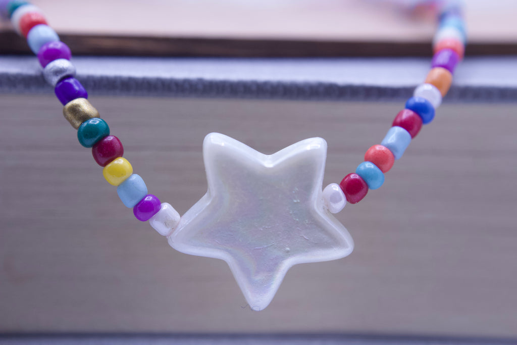 Colorful beaded necklace with a star-shaped pendant on a blurred background