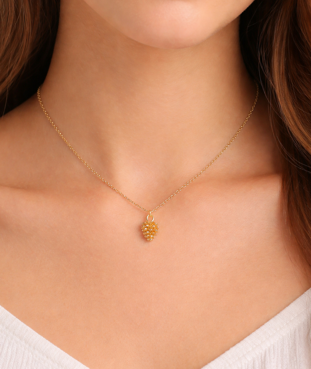 Dainty pinecone charm necklace in gold on delicate chain, minimalist nature inspired jewelry