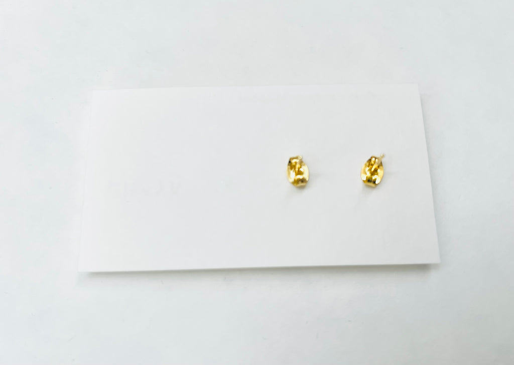 Gold earrings on a white card with a white background
