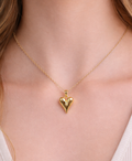 Gold heart-shaped necklace on a person's neck