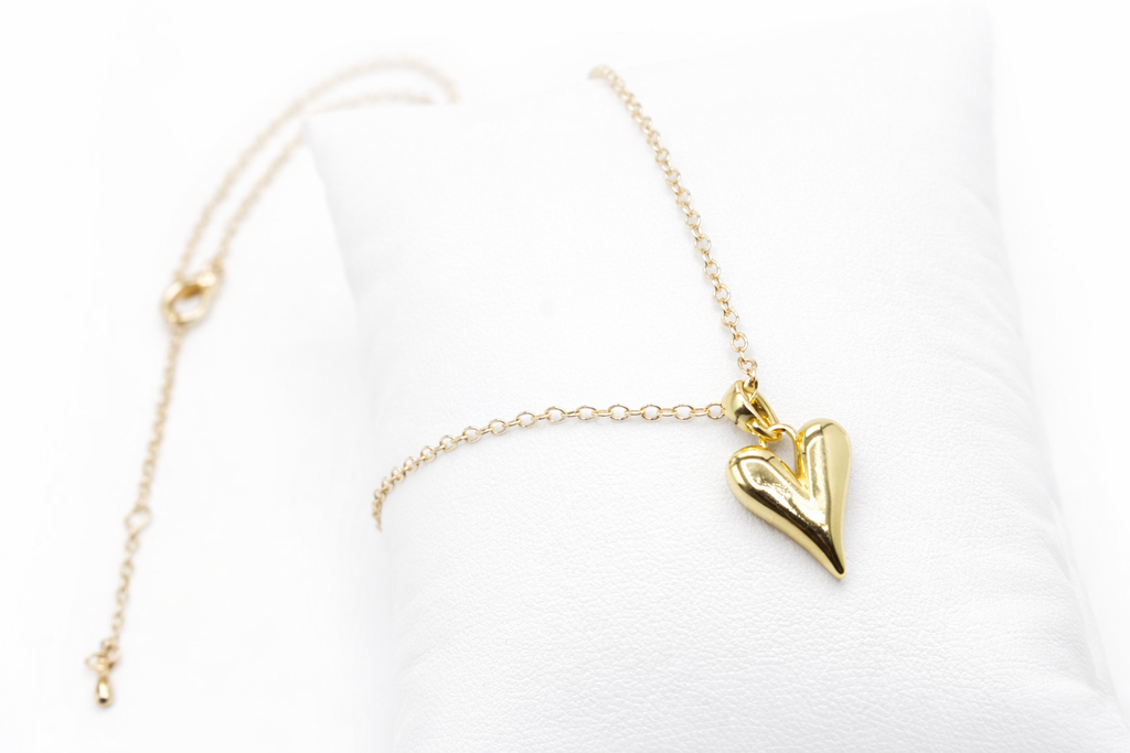 Gold heart-shaped pendant necklace on a white background