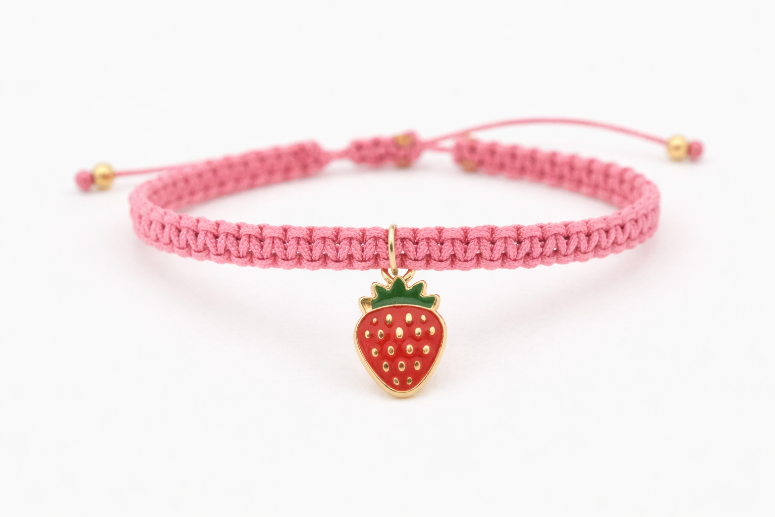 Handmade strawberry charm macrame bracelet on white background
