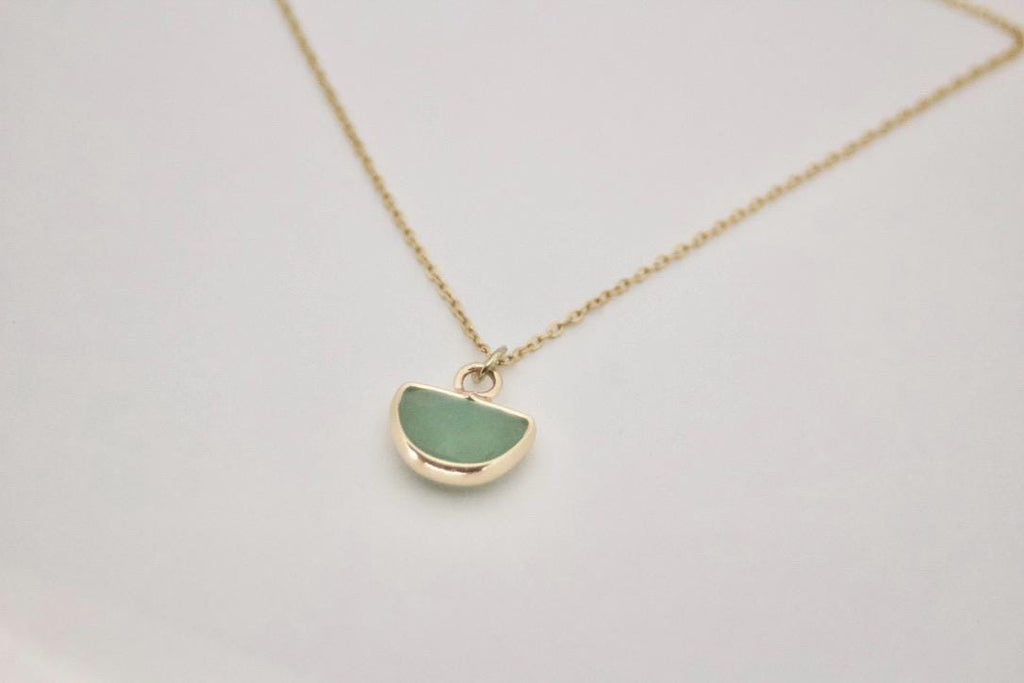 Minimalist green aventurine crystal necklace layered with gold jewelry