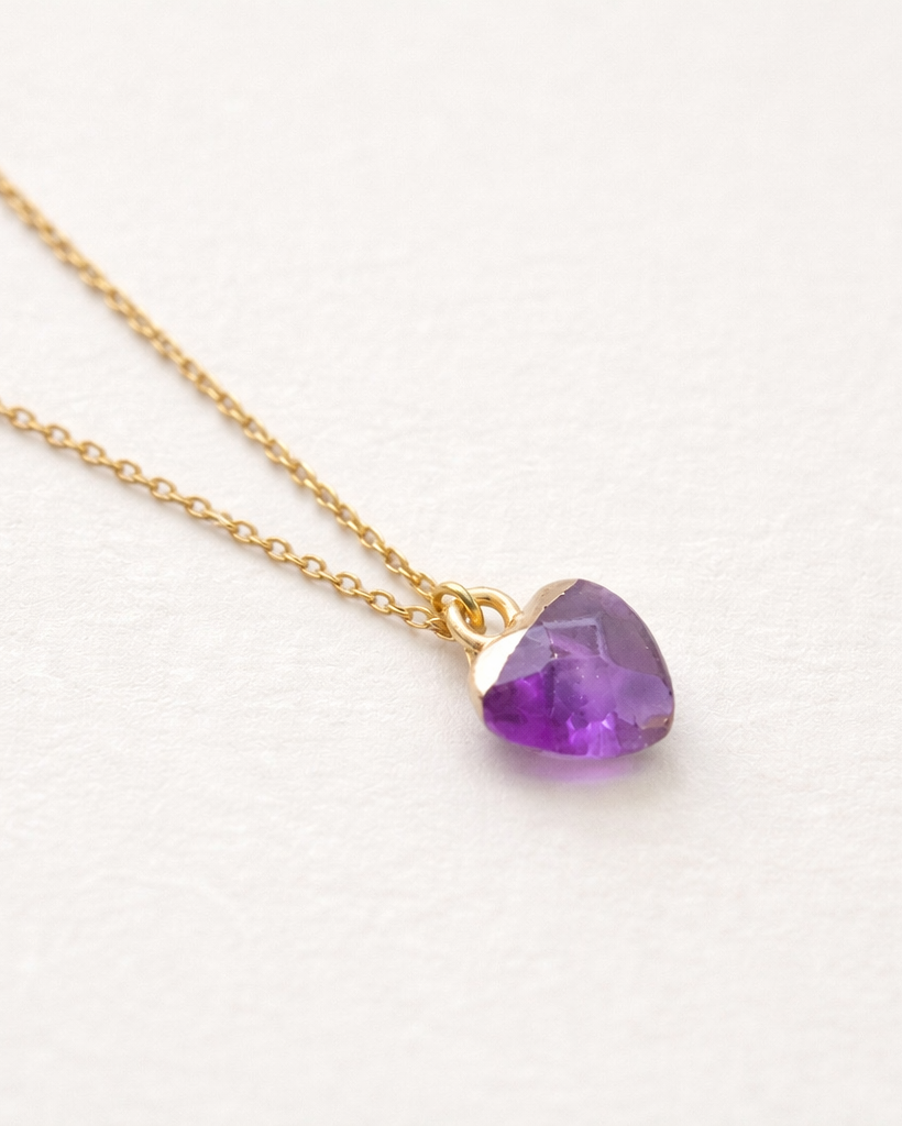 Necklace with a heart-shaped purple gemstone on a white background
