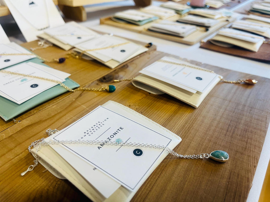 Jewelry displayed on books with cards on a wooden table