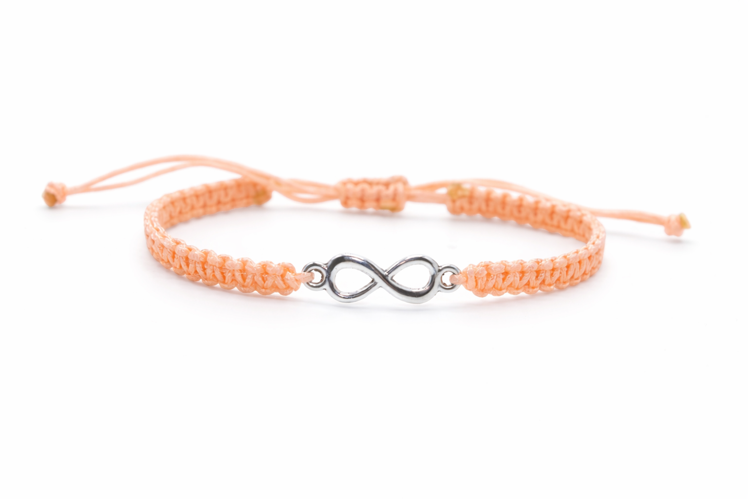 Peach-colored bracelet with an infinity symbol charm on a white background