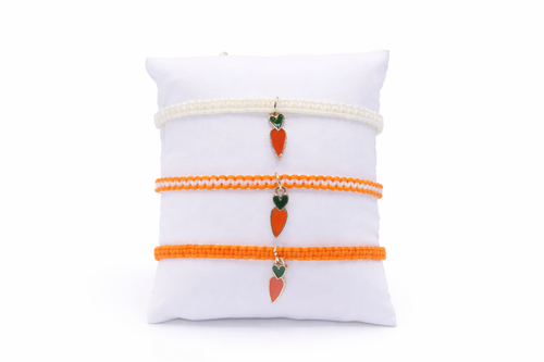 Set of three bracelets with carrot charms on a white pillow