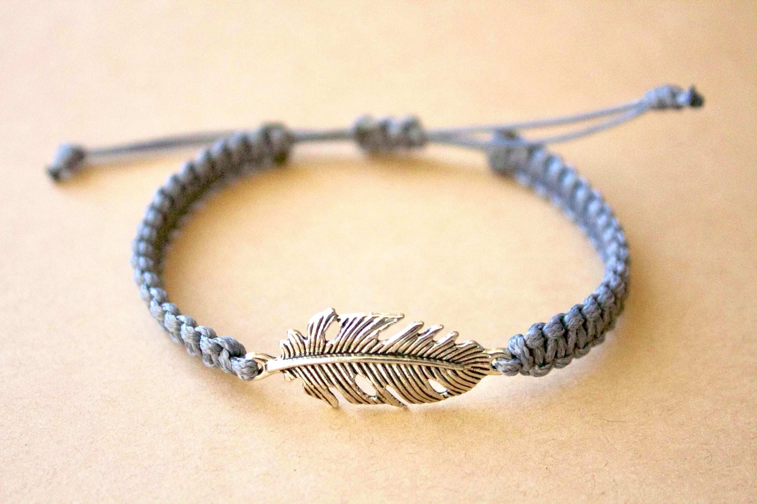 Bracelet with feather charm on a beige background