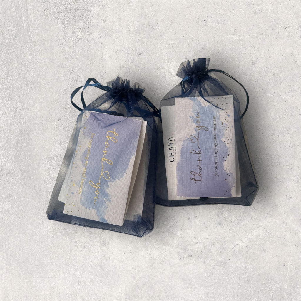 Two soap bars in black drawstring bags on a light gray background