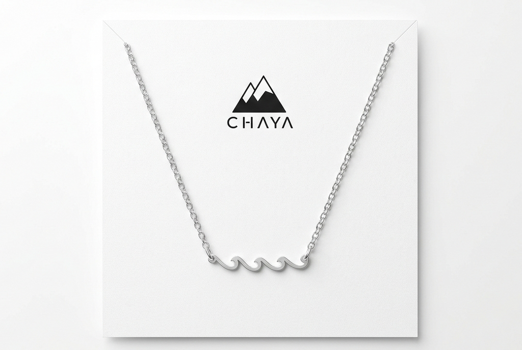 Silver necklace on a white card with 'Chaya' branding