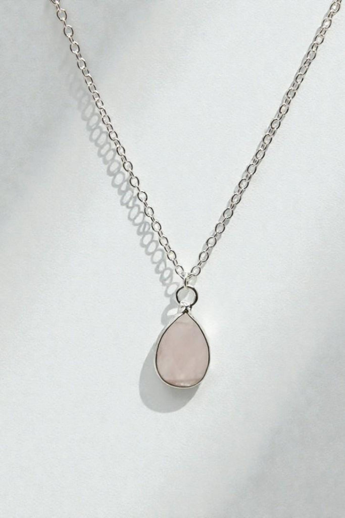Necklace with a teardrop-shaped pink pendant on a white background