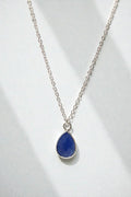 Necklace with a blue teardrop pendant on a white background
