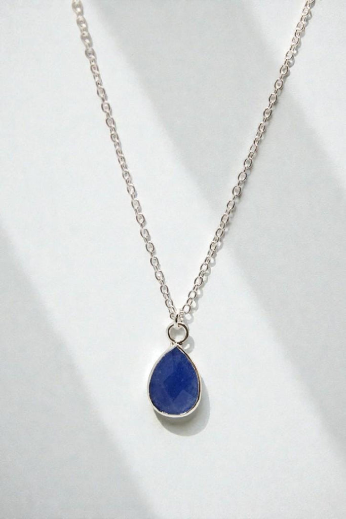Necklace with a blue teardrop pendant on a white background