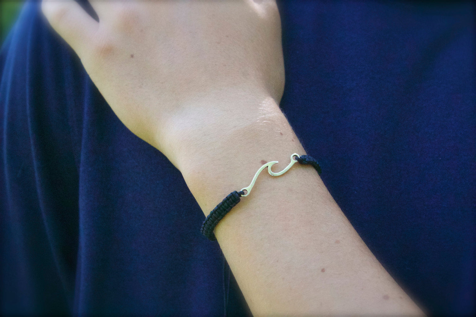 Bracelet with a unique design worn on a wrist against a blue background