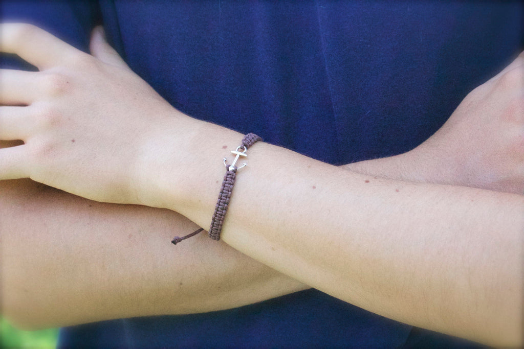 Close-up of a wrist wearing a bracelet with a blue shirt in the background