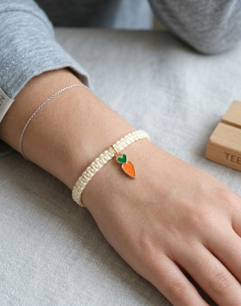 cream bracelet with a carrot charm on model wrist
