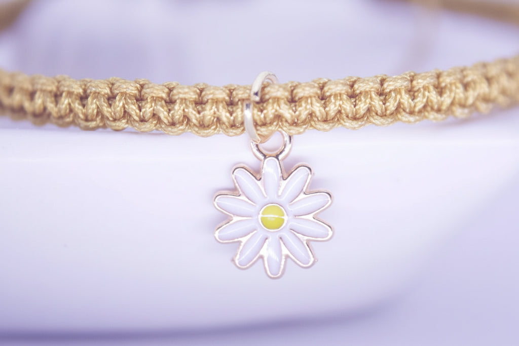 Bracelet with a daisy charm on a light purple background