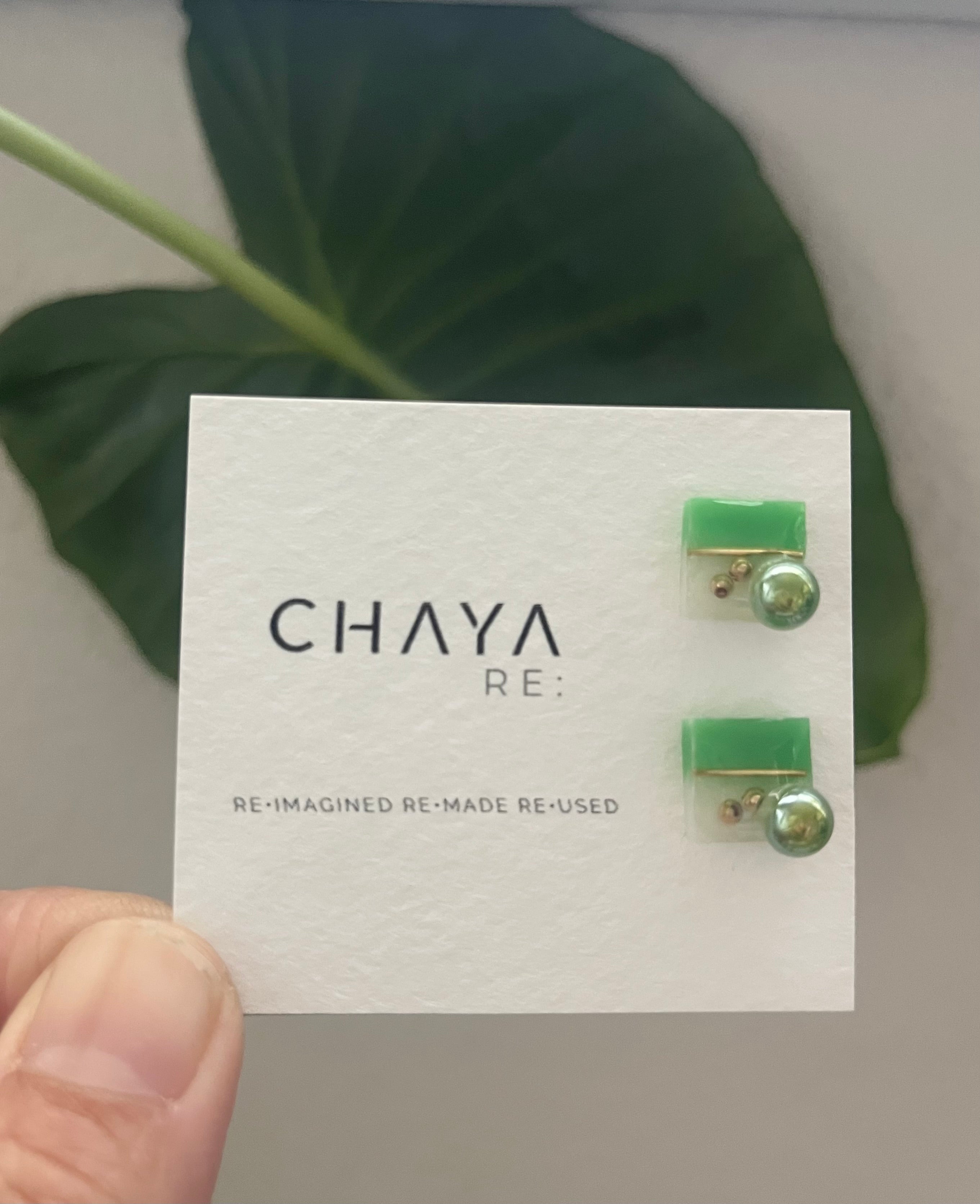 Green earrings on a Chaya branded card with a leaf in the background