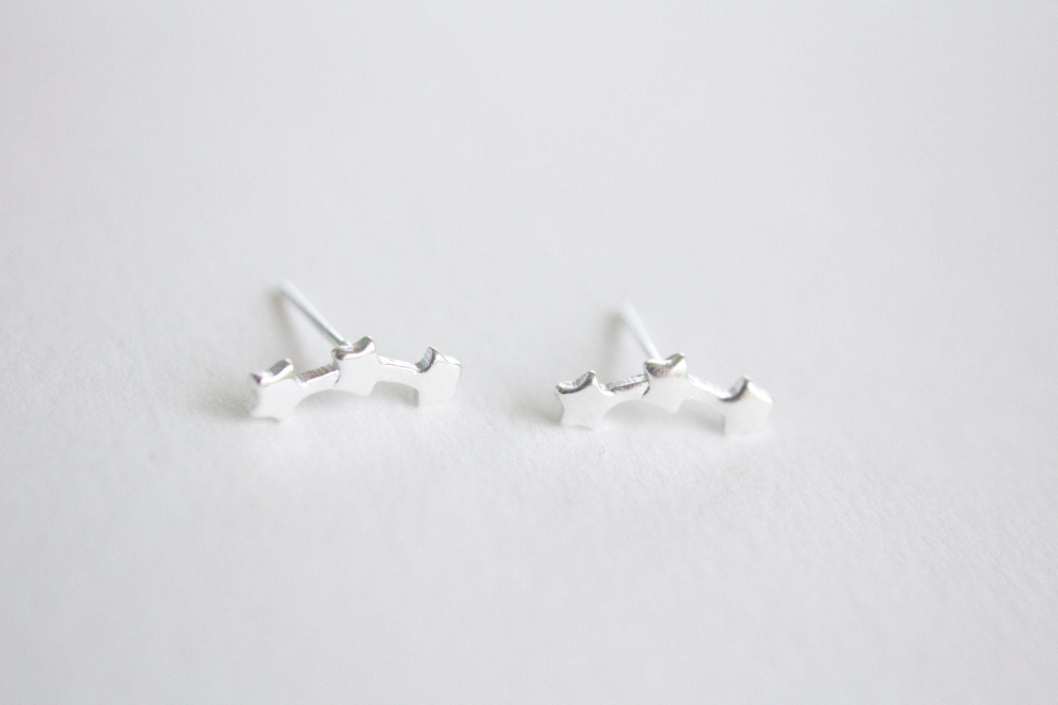 Pair of silver earrings on a light gray background