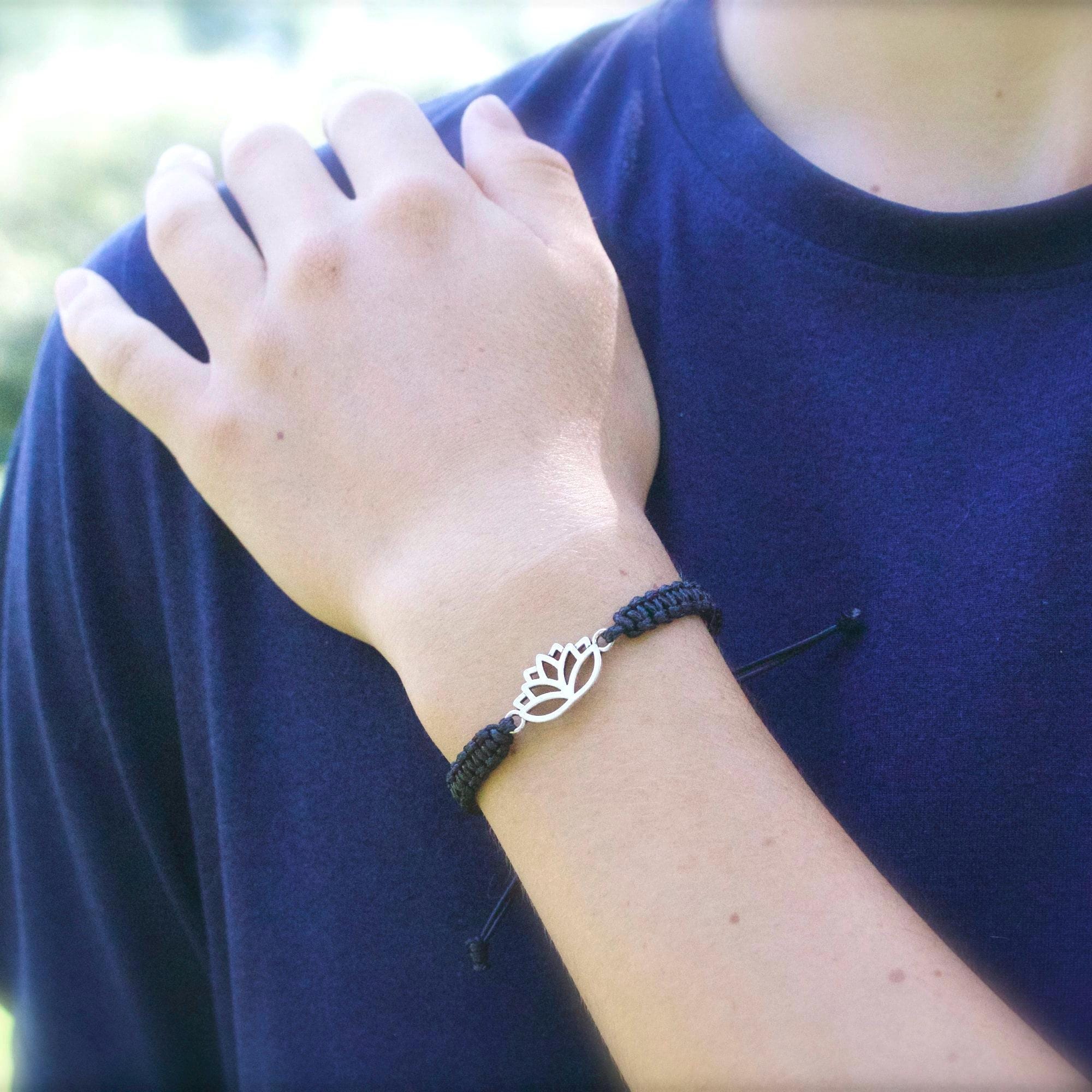 Person wearing a bracelet with a leaf design on a blurred background