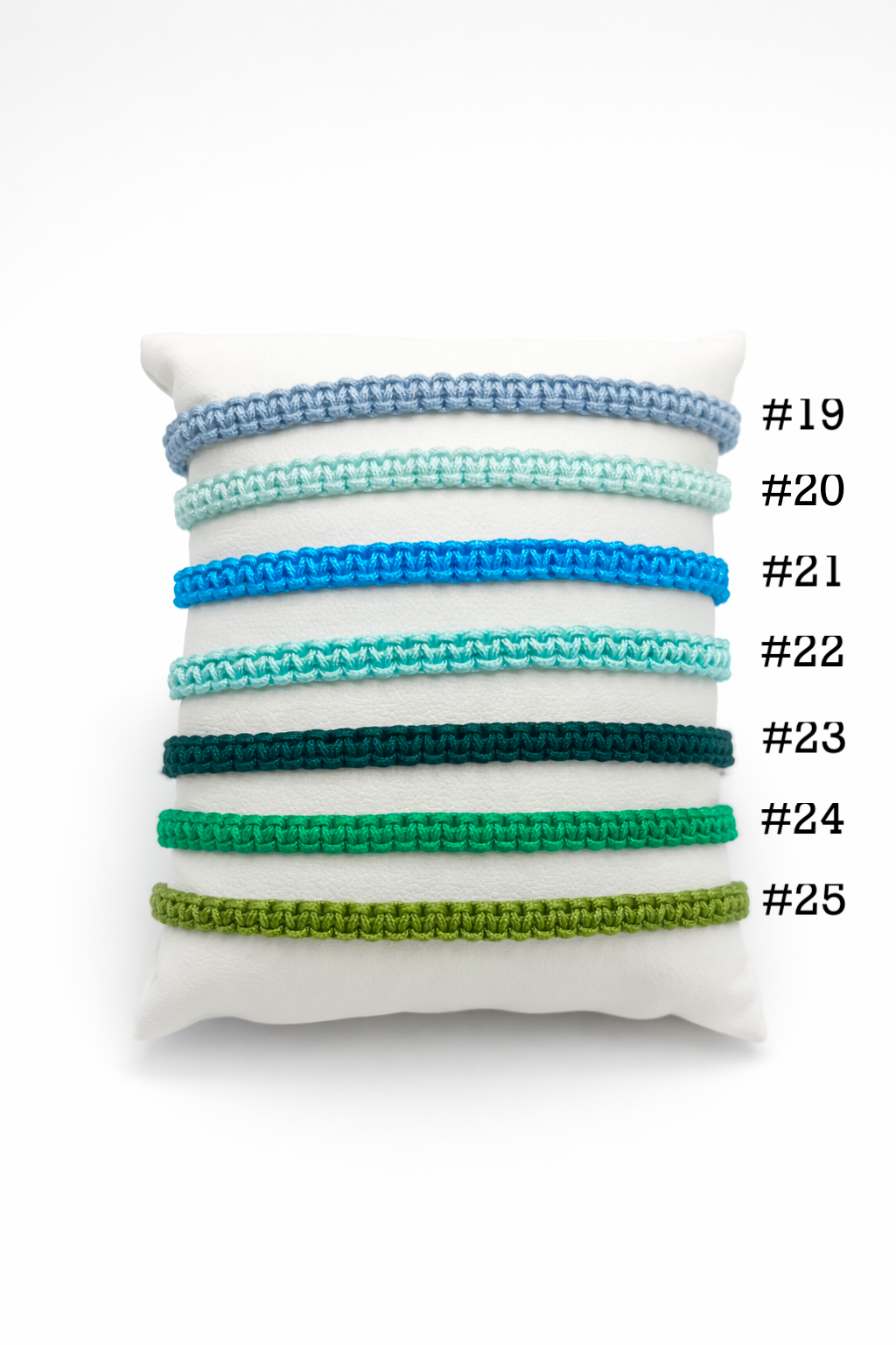 Set of colorful bracelets on a white pillow with numbers indicating color options.