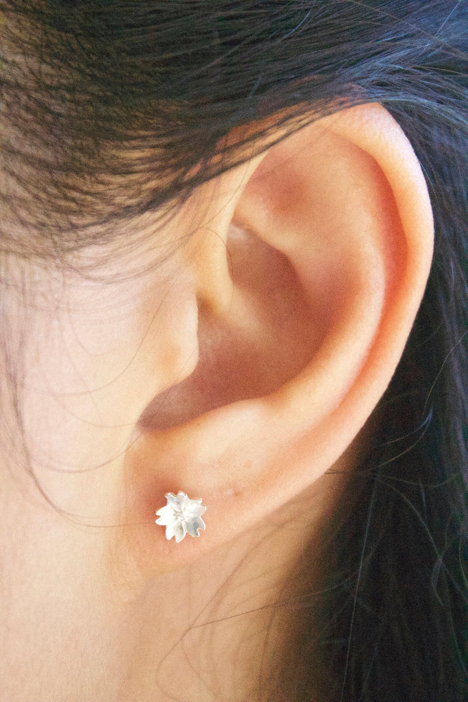 minimalist silver flower studs worn on ear elegant gift for her