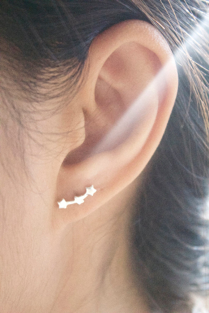 minimalist silver star stud earrings worn on ear everyday jewelry