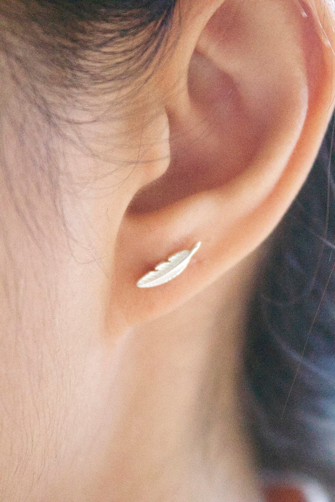 minimalist tiny leaf silver earrings worn on ear