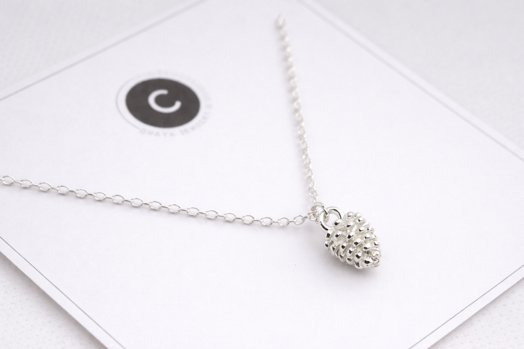Silver necklace with a textured pendant on a white background