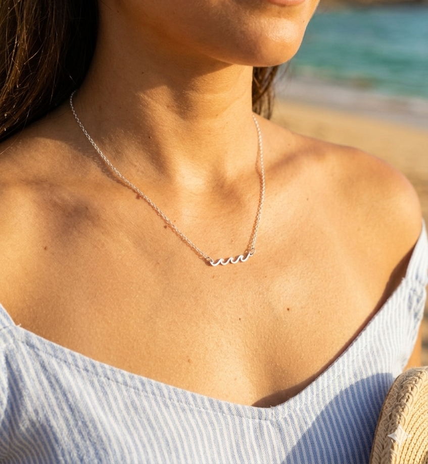 silver  wave necklace on model with a blurred beach background