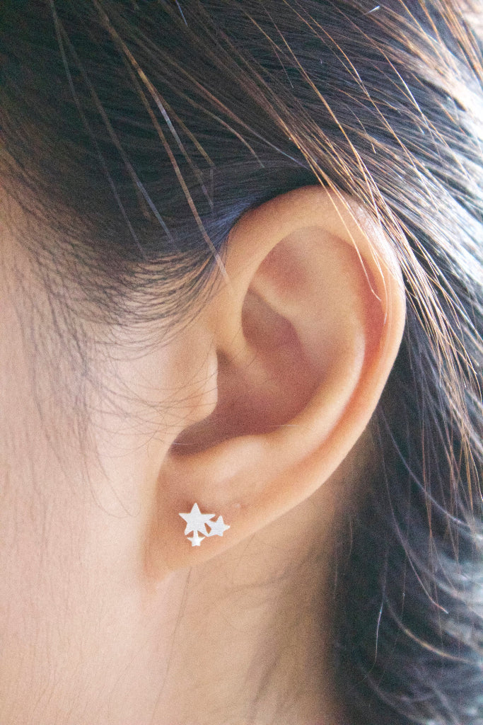 trio star studs worn on ear minimalist accessory
