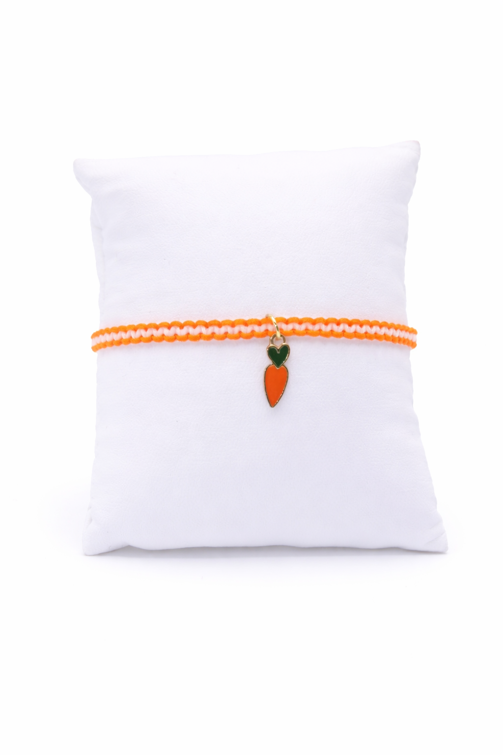 two tone bracelet with carrot charm on white pillow
