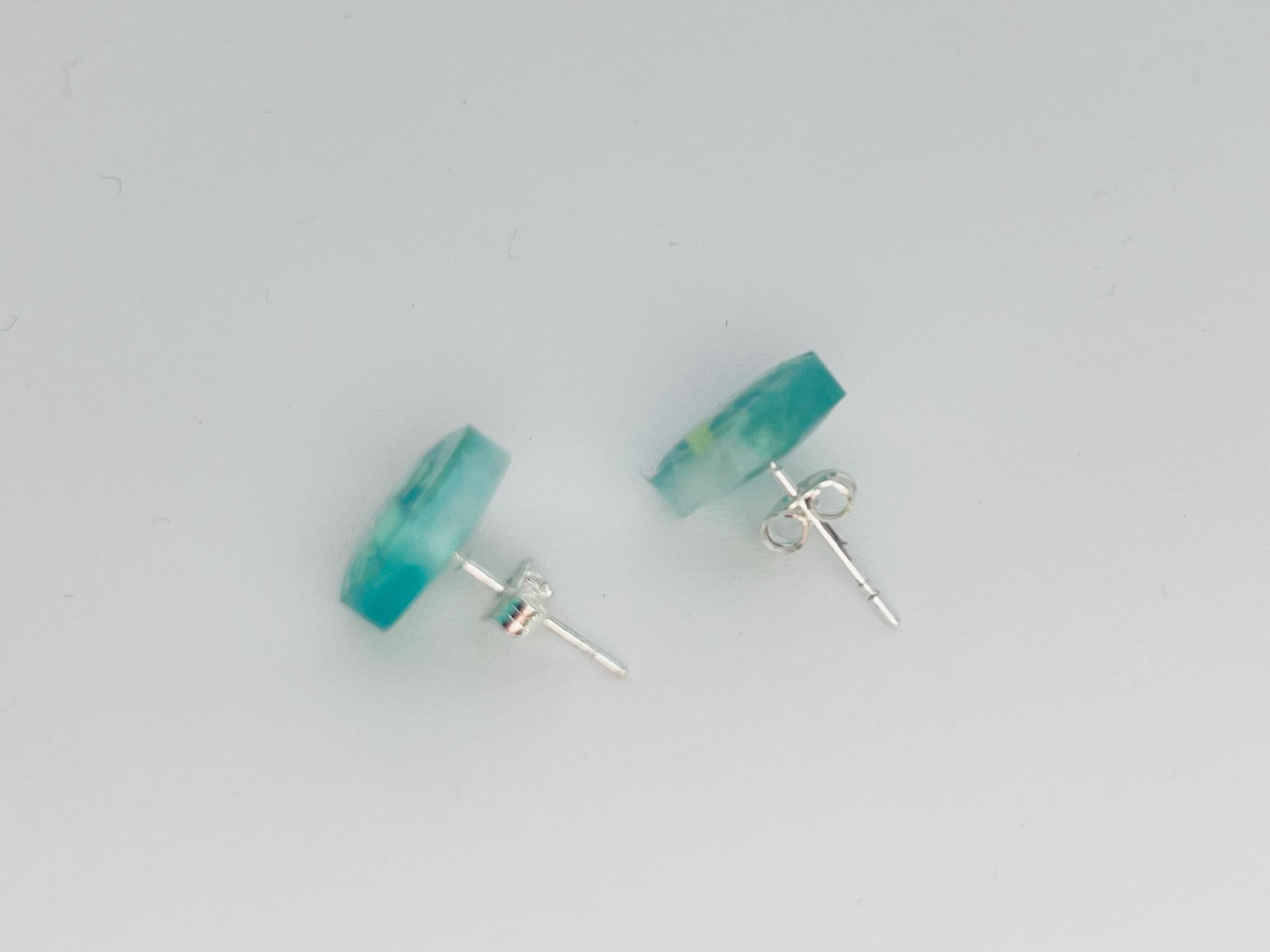 Pair of turquoise stud earrings on a light gray background